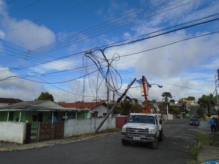 foto mostra foto da rede de energia quebrado, fiação no chão e equipes de manutenção da Cocel fazendo o conserto