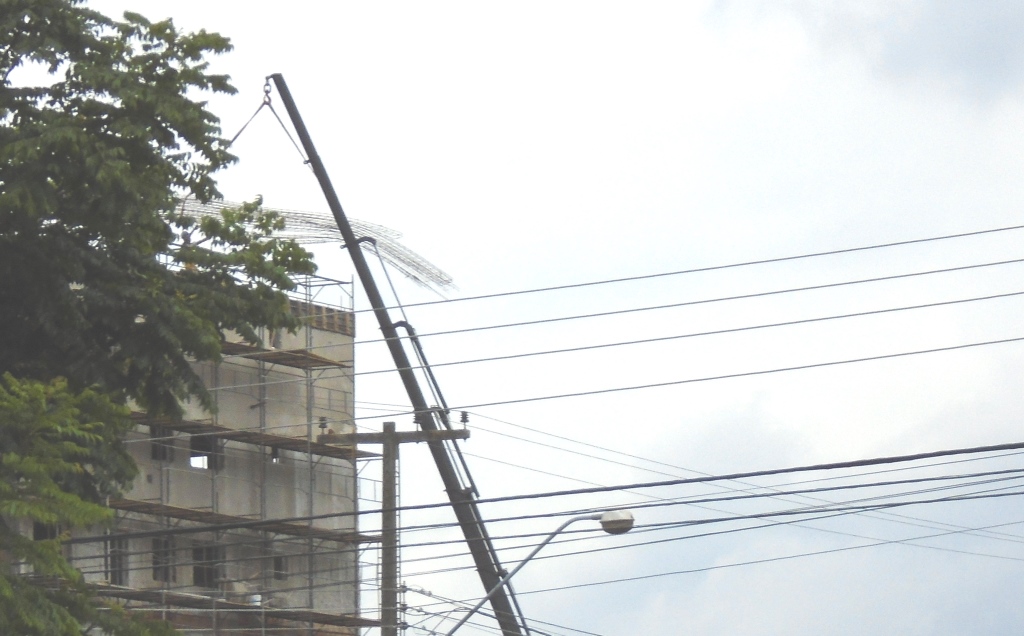 Foto de barra de ferro de prédio em construção caída em cima da rede