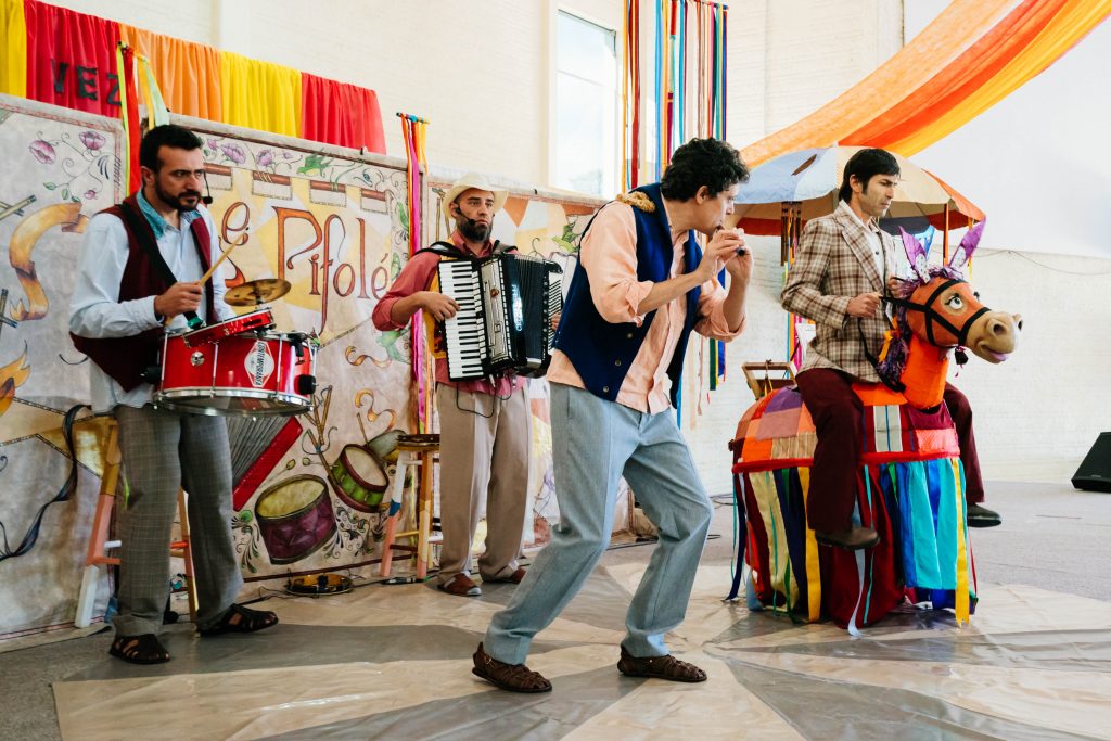 foto do palco do teatro Le Pifolé mostrando 4 atores e seus instrumentos musicais